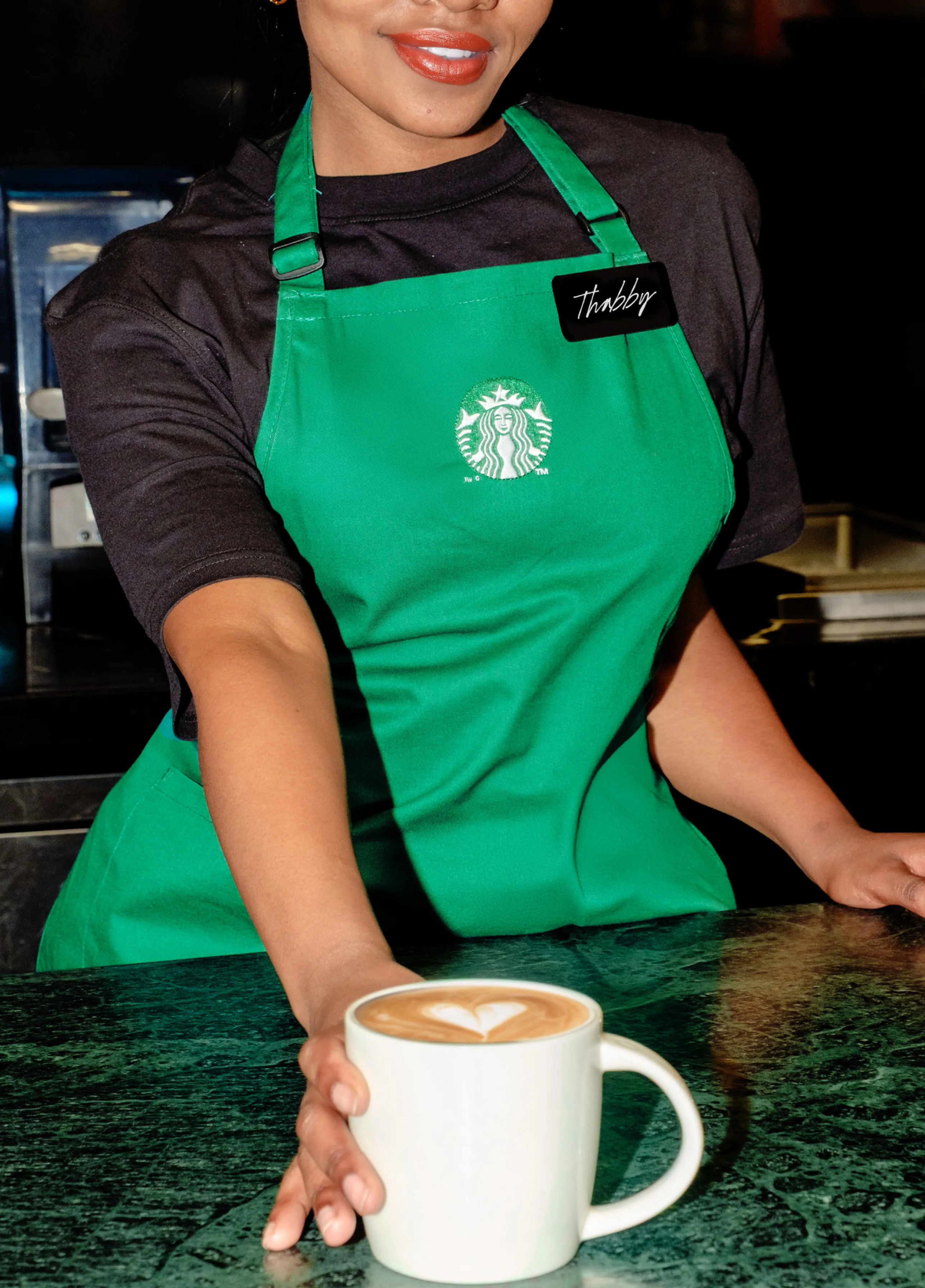 A Starbucks Partner handing off a latte
